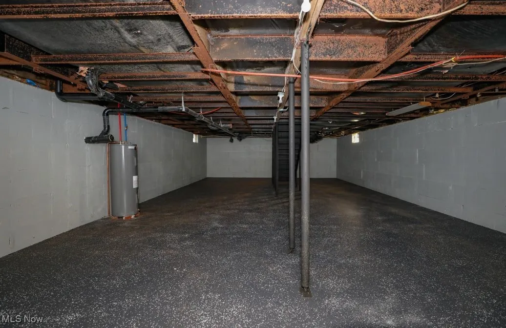 Unfinished basement featuring electric water heater