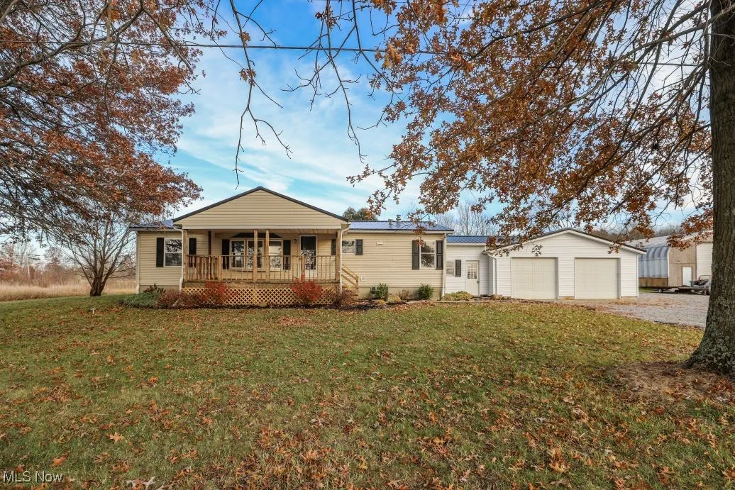 View of front of house with a front yard, covered porch, and driveway