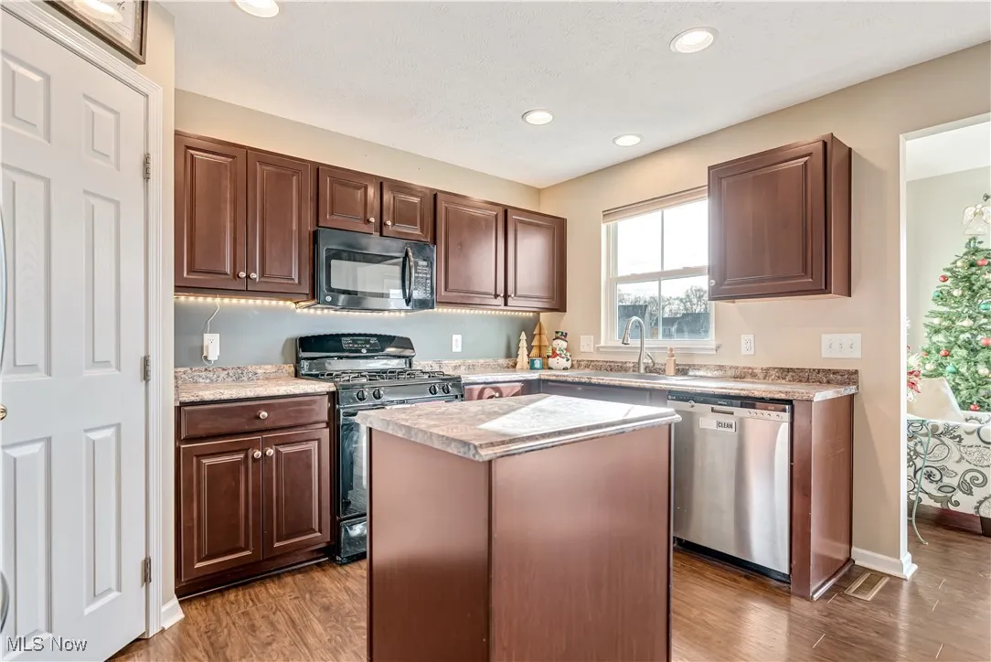 Kitchen featuring espresso cabinetry and stainless steel and black appliances