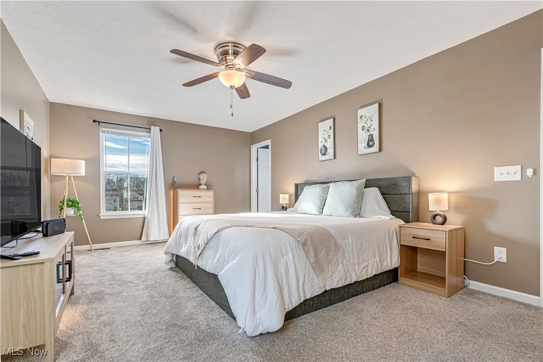 Primary Bedroom featuring light colored carpet and ceiling fan