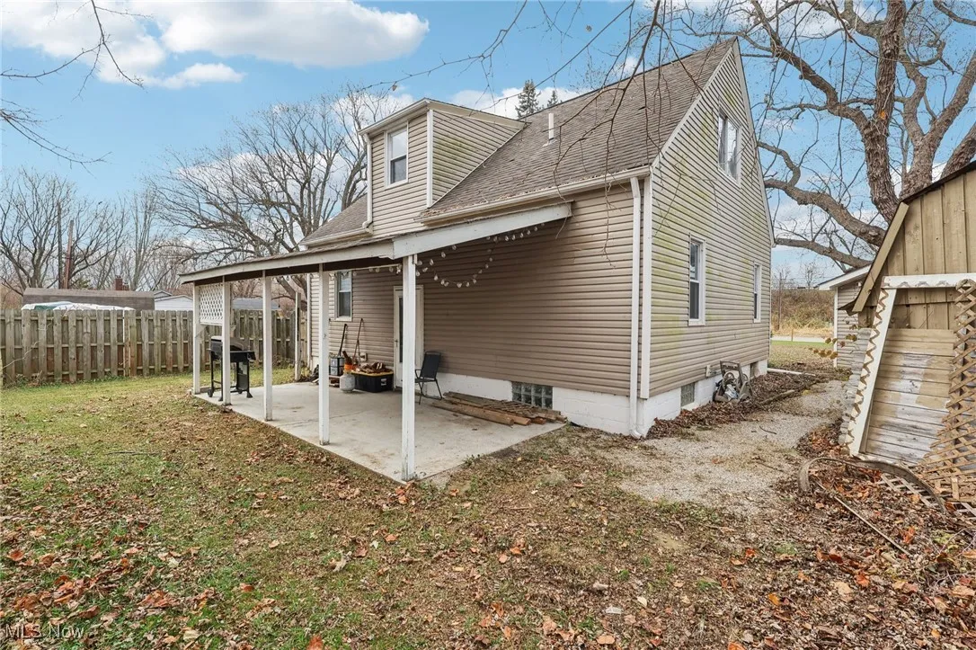 Rear view of property with roof with shingles and a patio area