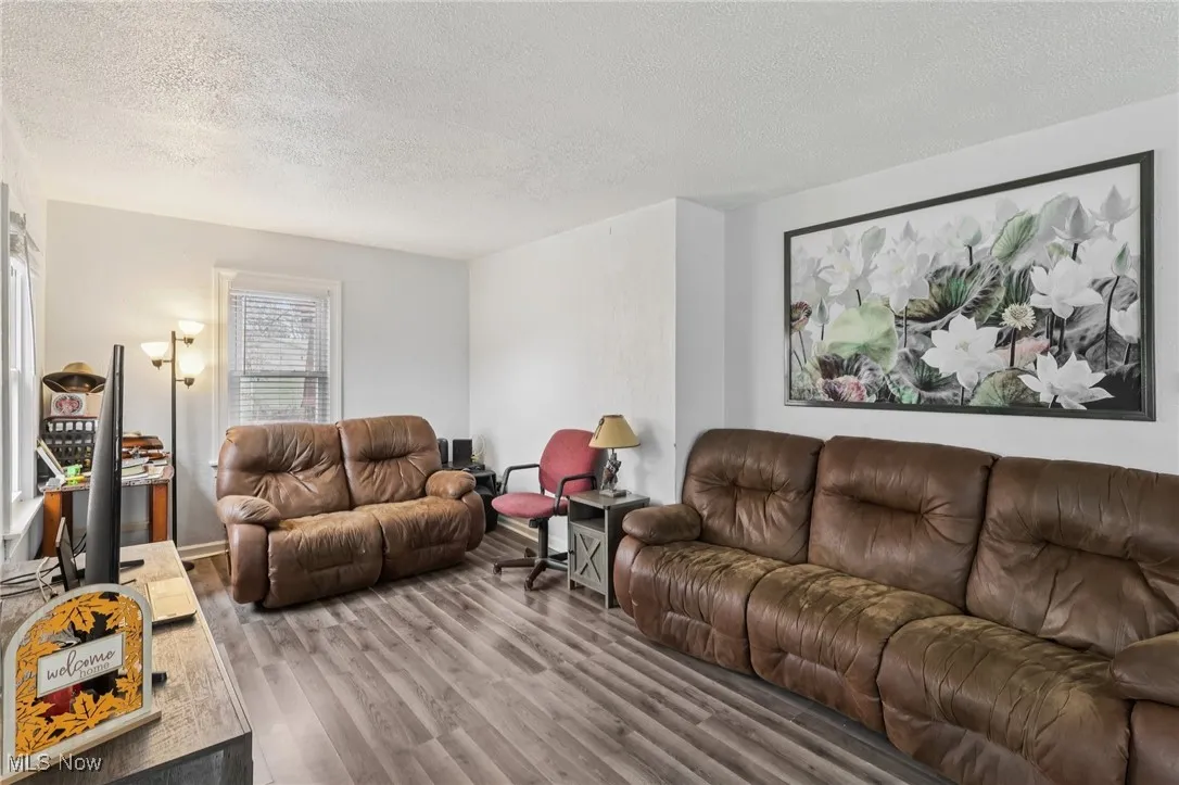 Living room with a textured ceiling and wood finished floors