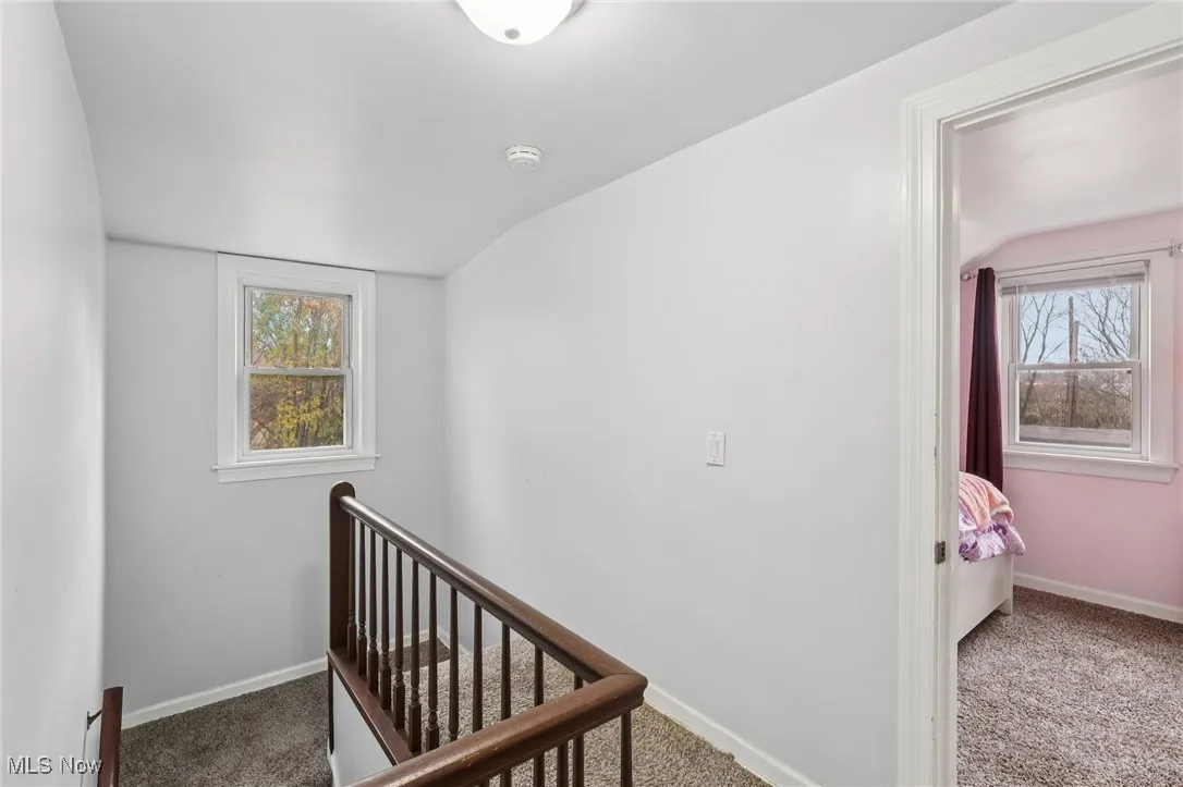 Hall featuring carpet and an upstairs landing