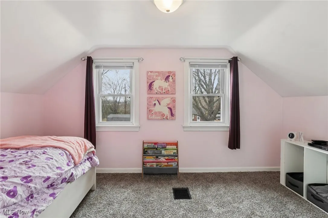 Bedroom featuring carpet flooring and lofted ceiling