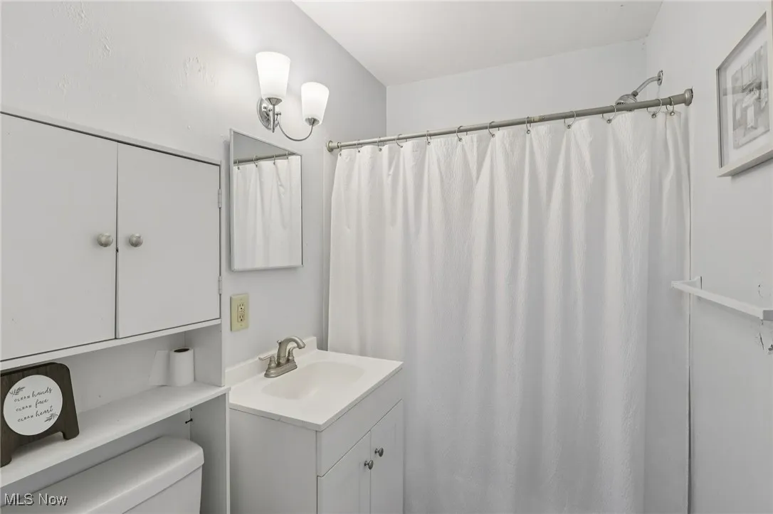Full bathroom with a shower with shower curtain and vanity