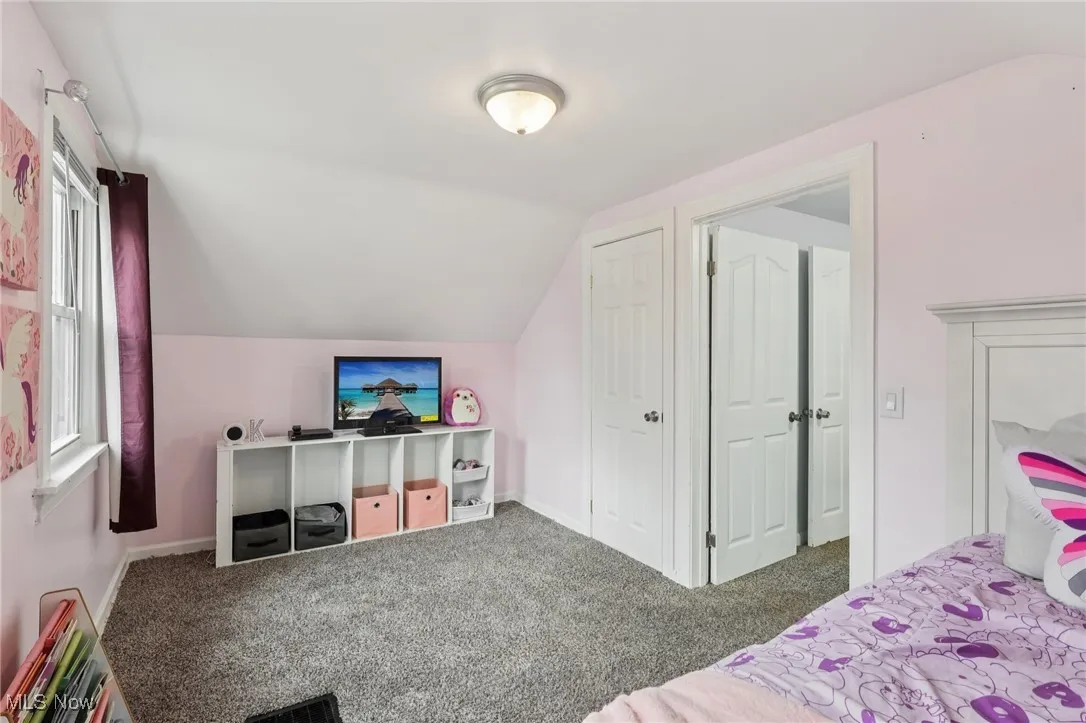 Bedroom with lofted ceiling and carpet floors
