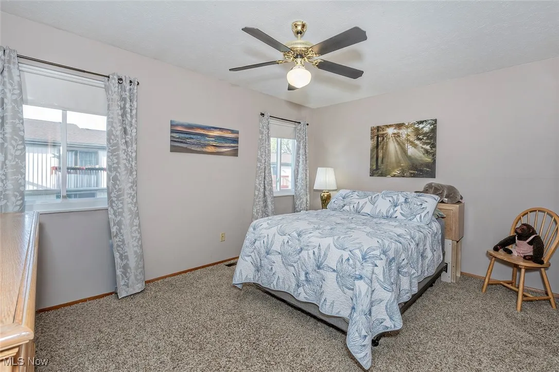 Bedroom with light colored carpet and ceiling fan