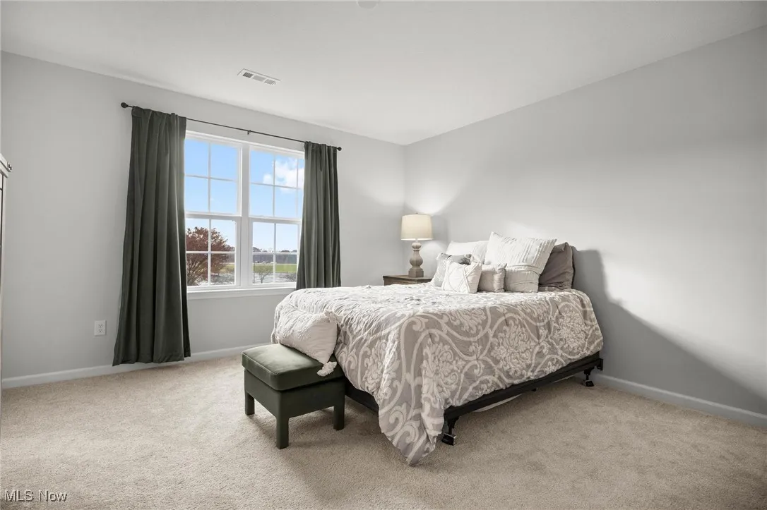 Bedroom featuring light carpet and baseboards