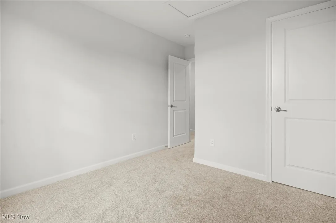 Unfurnished bedroom with light colored carpet and baseboards