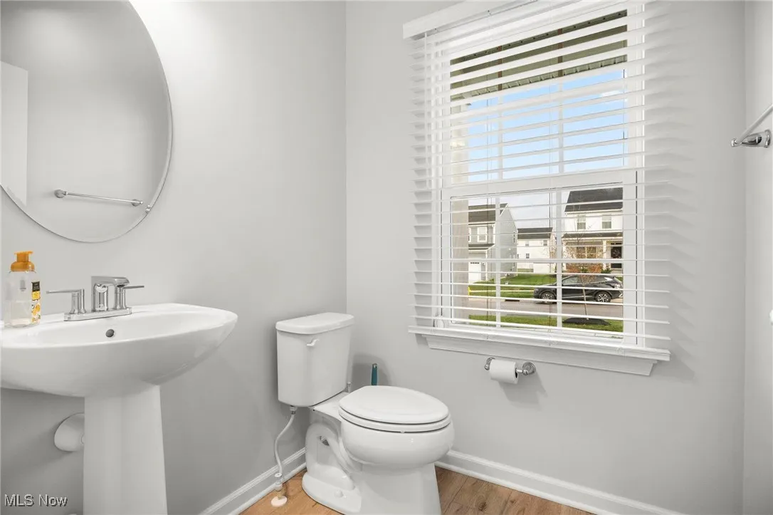 Half bath with toilet and light wood-style floors