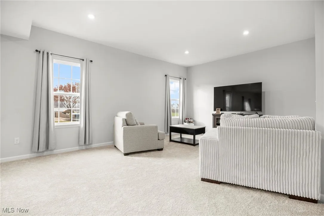 Living room featuring light colored carpet, healthy amount of natural light, and recessed lighting