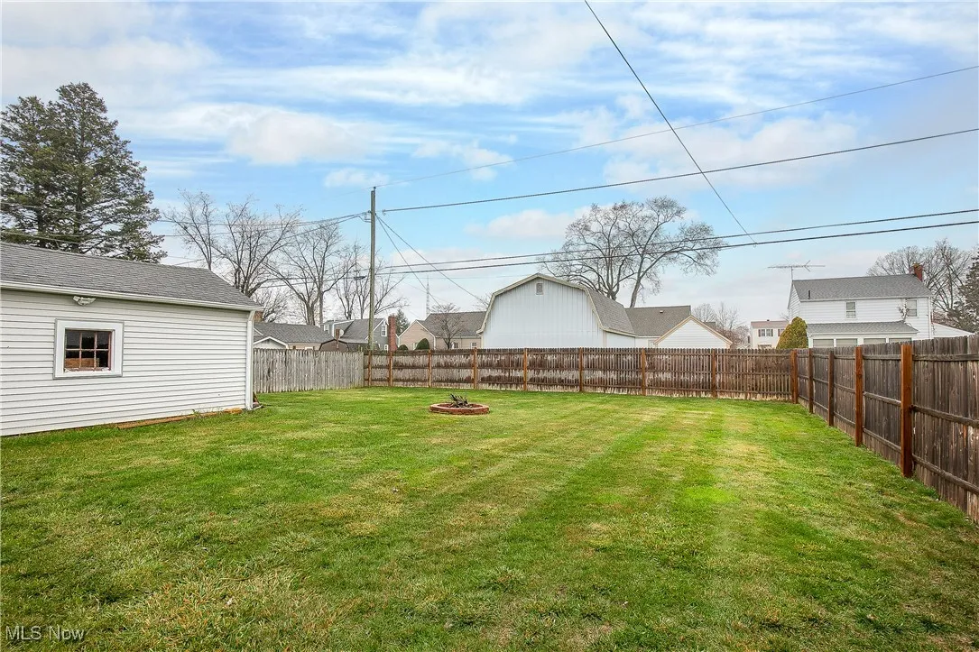 Fenced backyard with a fire pit
