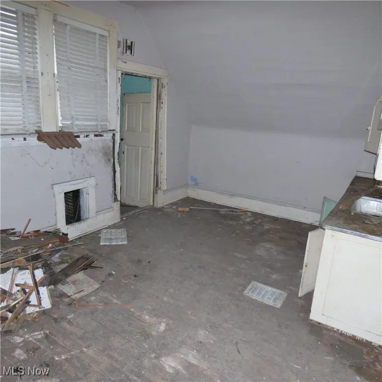 Unfurnished living room featuring lofted ceiling and a high end fireplace