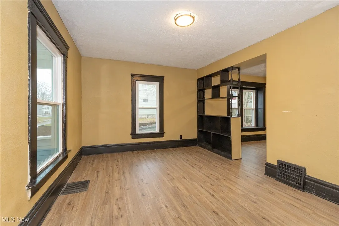 Spare room with light wood finished floors and a textured ceiling