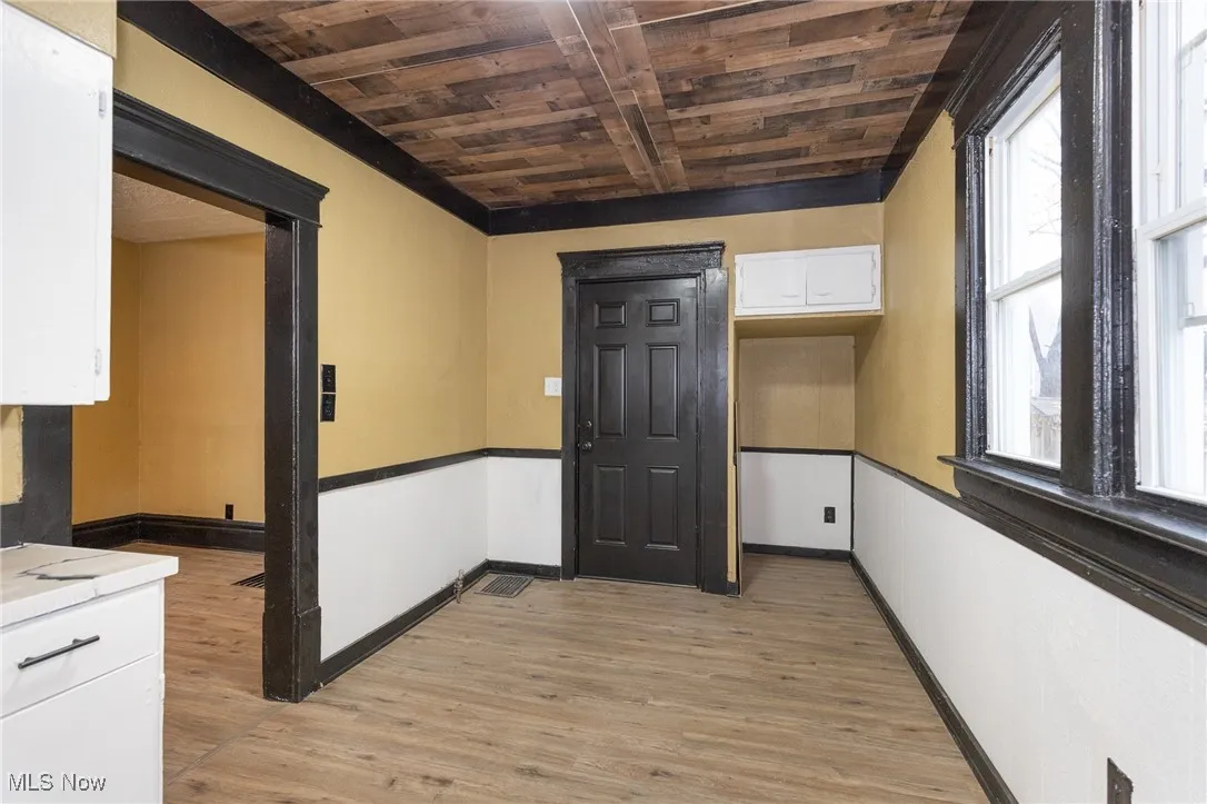 Hallway with light wood finished floors and wooden ceiling