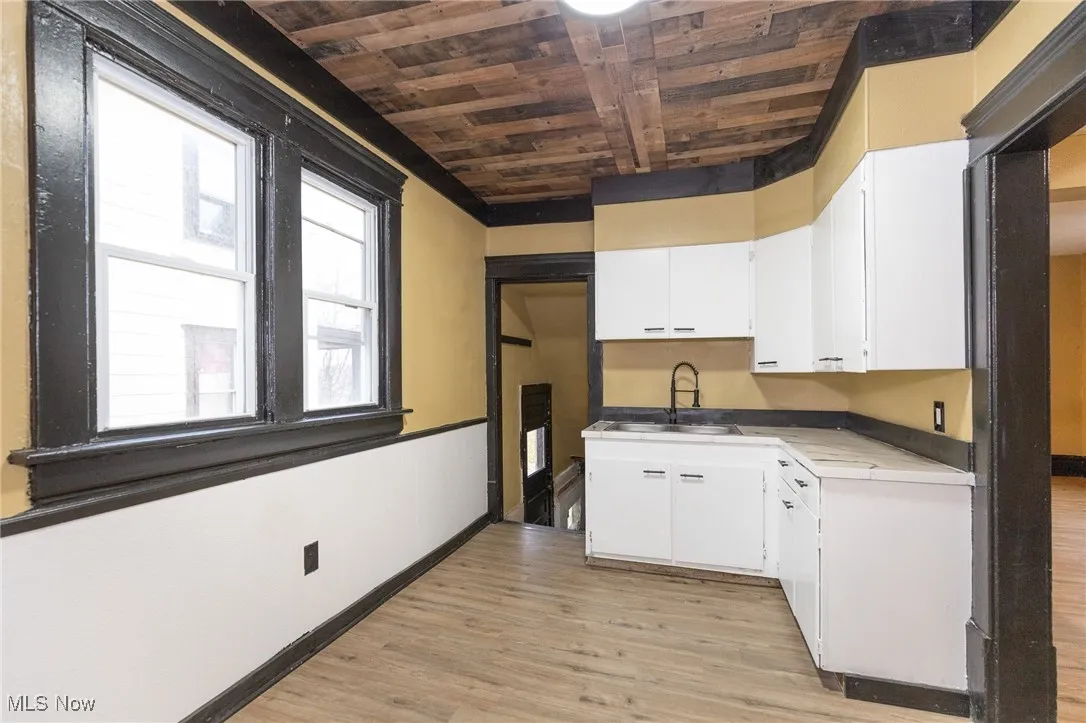Kitchen featuring white cabinets, wooden ceiling, and light wood-style flooring