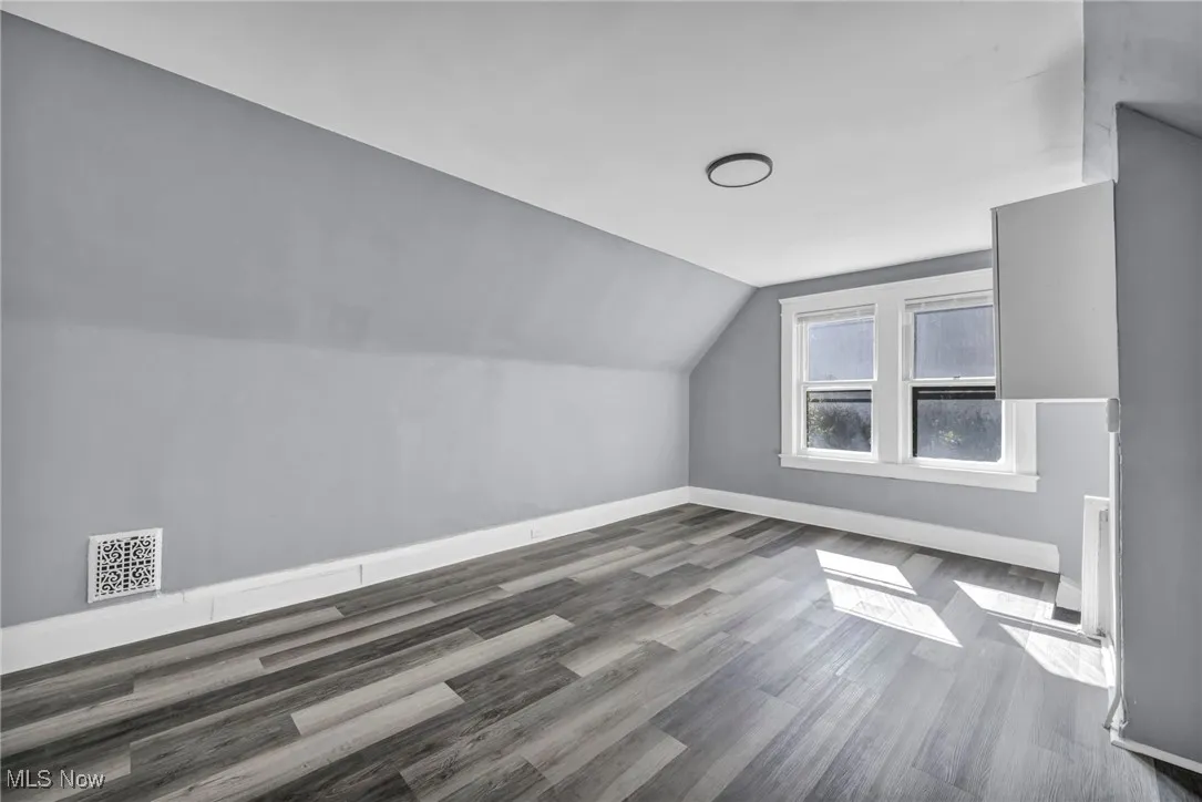 Additional living space with vaulted ceiling and wood finished floors