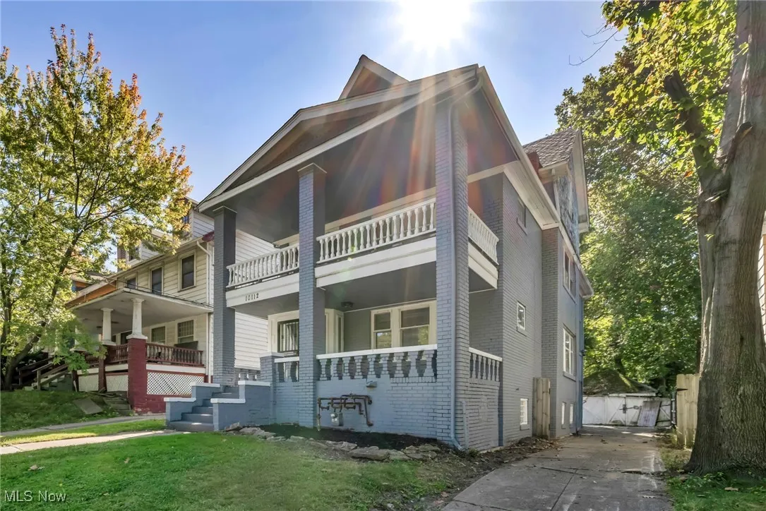 View of front facade featuring covered porch, brick siding, and a front lawn