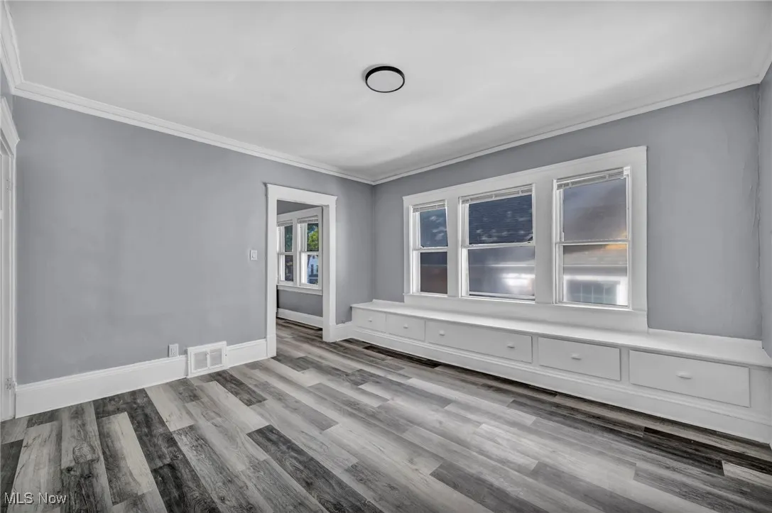 Empty room featuring crown molding and light wood-style flooring