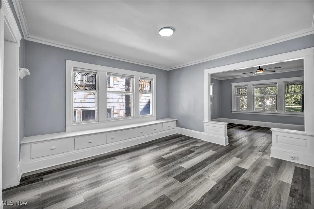 Unfurnished room with crown molding, wood finished floors, and ceiling fan