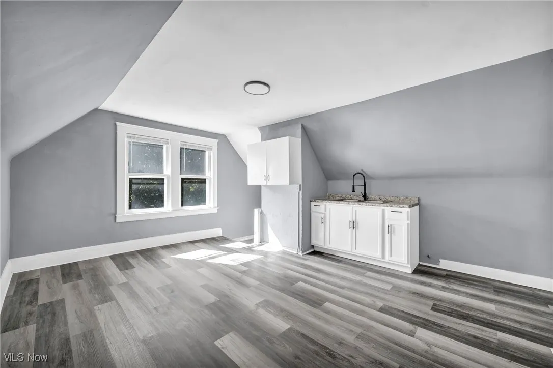 Bonus room with vaulted ceiling and light wood finished floors