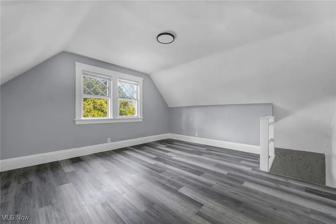 Additional living space with vaulted ceiling and wood finished floors