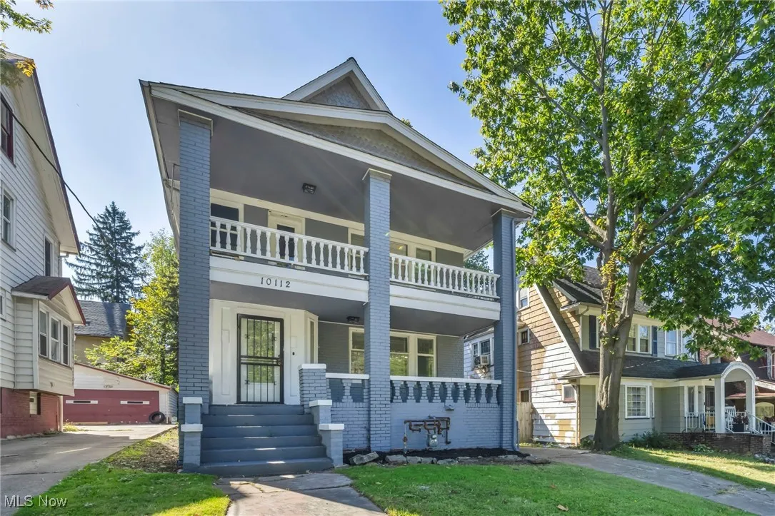 View of front of house featuring brick siding, a porch, and a front lawn