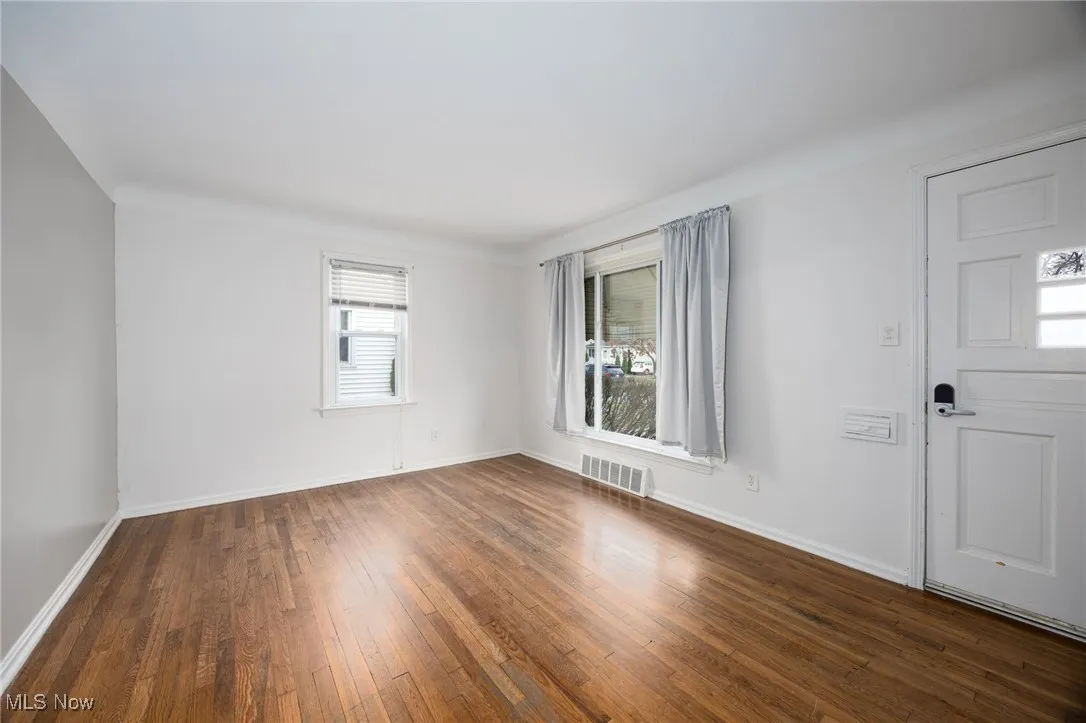 Unfurnished room with dark wood-type flooring and baseboards