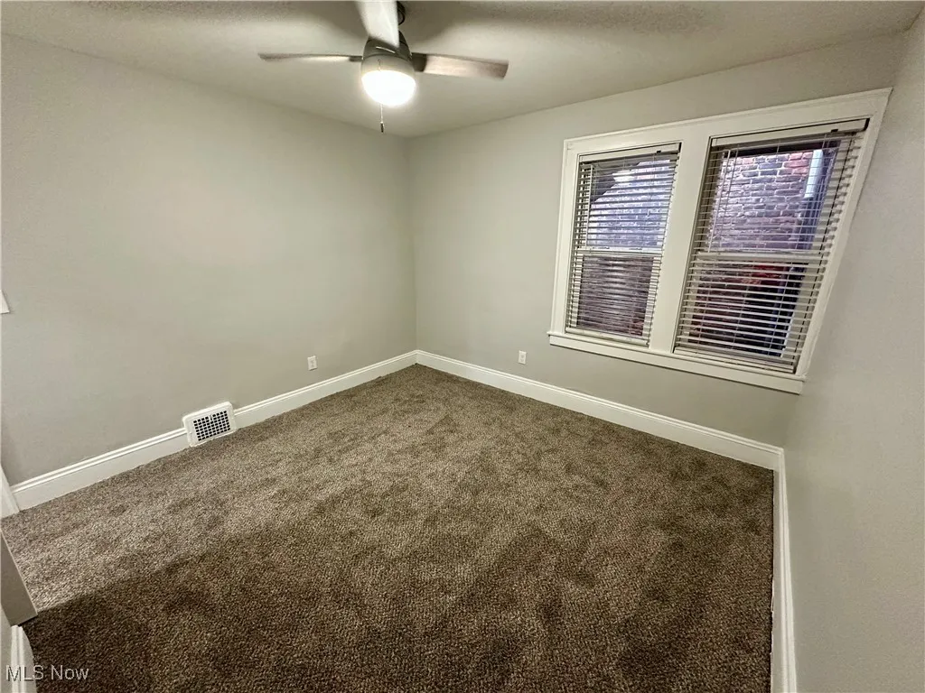 Empty room with carpet, a textured ceiling, and ceiling fan
