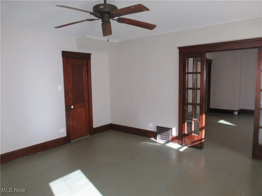 Unfurnished room featuring a ceiling fan, french doors, and wood finished floors