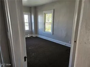 Unfurnished room with dark colored carpet