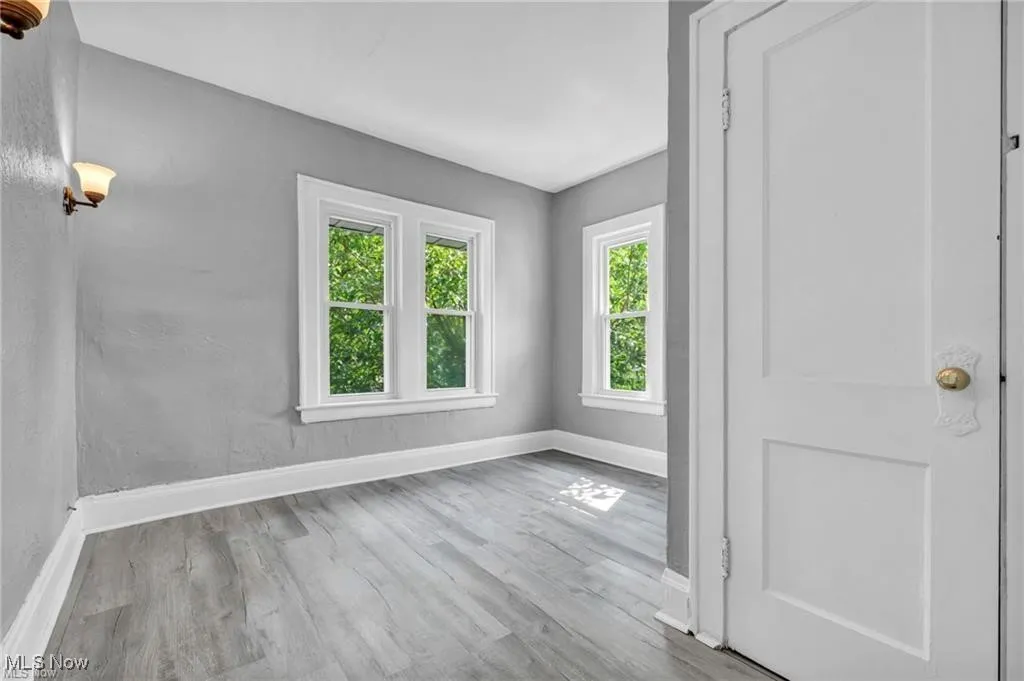 Empty room with light hardwood / wood-style floors and a wealth of natural light