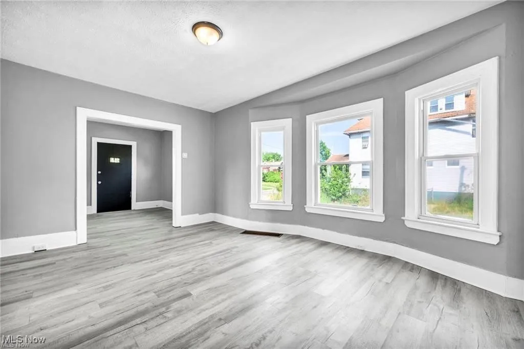 Spare room with light hardwood / wood-style flooring and vaulted ceiling