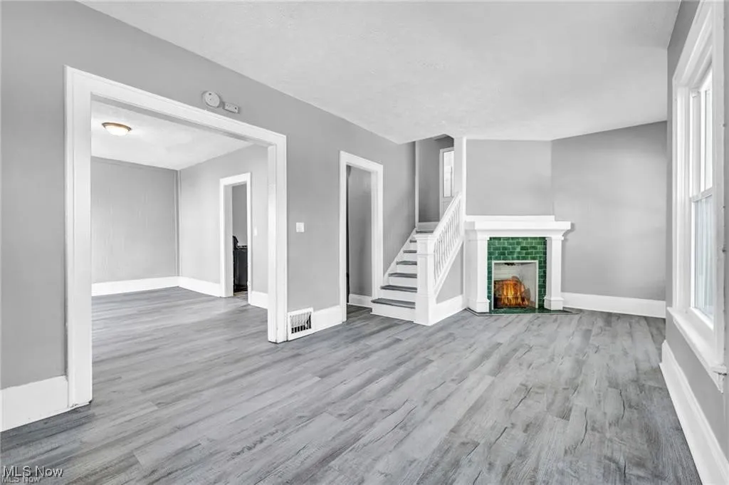 Unfurnished living room with hardwood / wood-style flooring and a brick fireplace