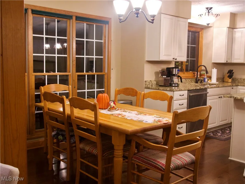 Dining room with dark wood finished floors and a chandelier