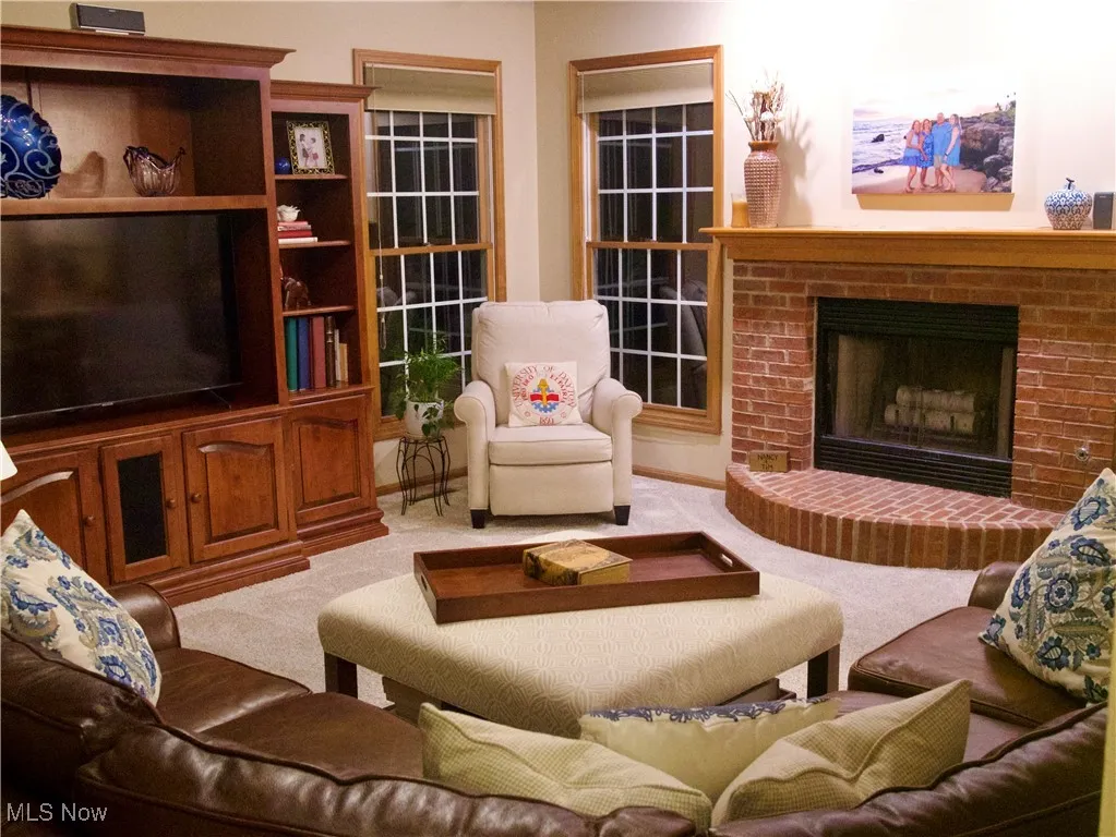 Carpeted living area featuring a fireplace