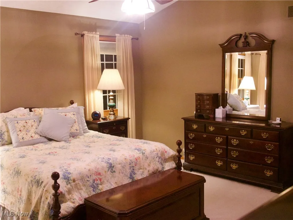 Carpeted bedroom featuring a ceiling fan