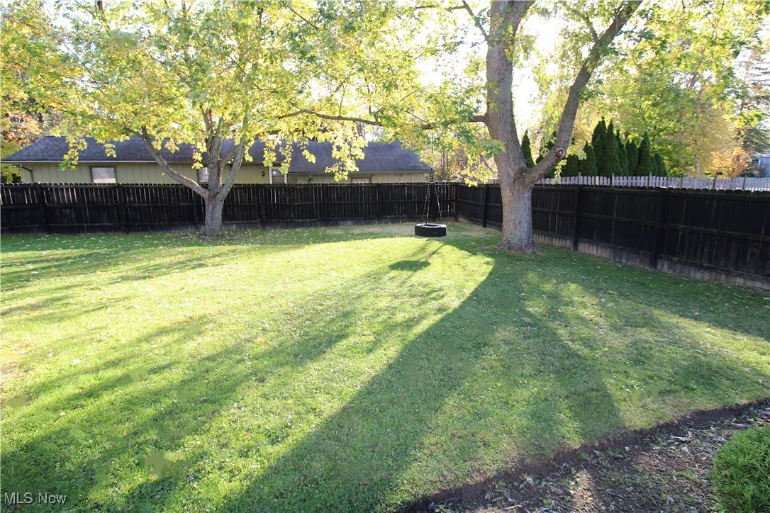 View of Spacious Fully Fenced Yard and Tire Swing