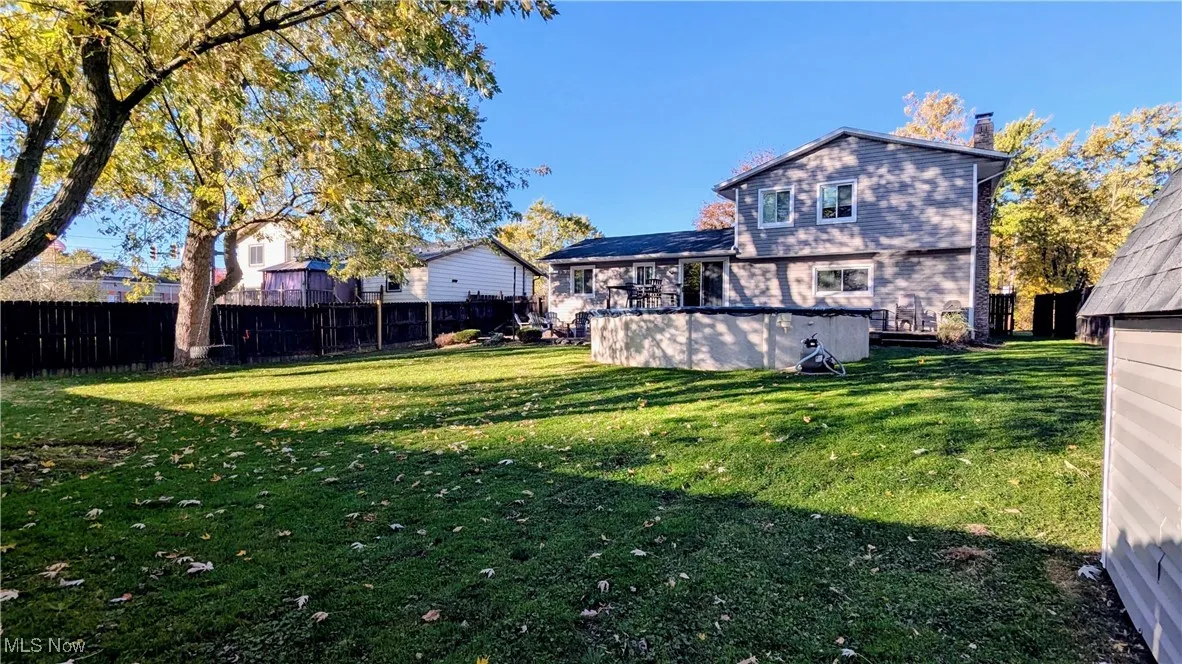 View of Back of Home and Spacious Backyard .37 Acres lot, Fully Fenced Yard, Vinyl Storage Shed, Two Tier Deck, Newer Above Ground Pool, Patio with Firepit