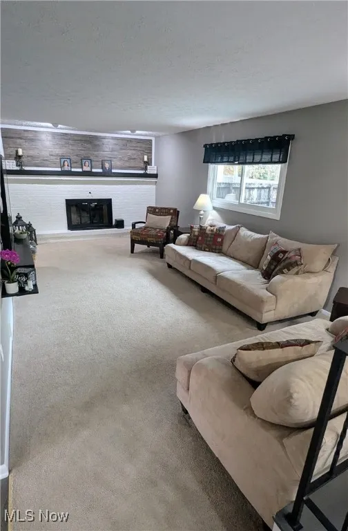 View of Spacious Family Room with Updated Fireplace with Mantel, Carpet, Window Treatments and Modern Paint