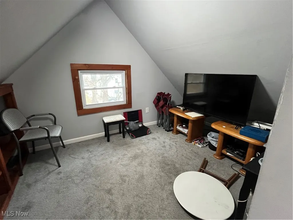 Living area featuring light carpet and lofted ceiling