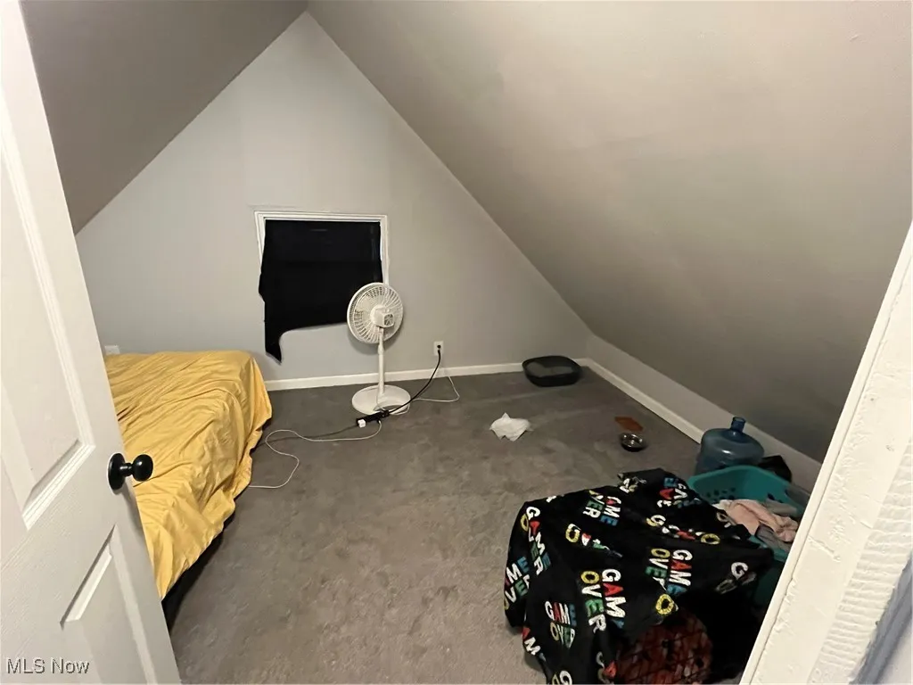 Bedroom with carpet floors and lofted ceiling