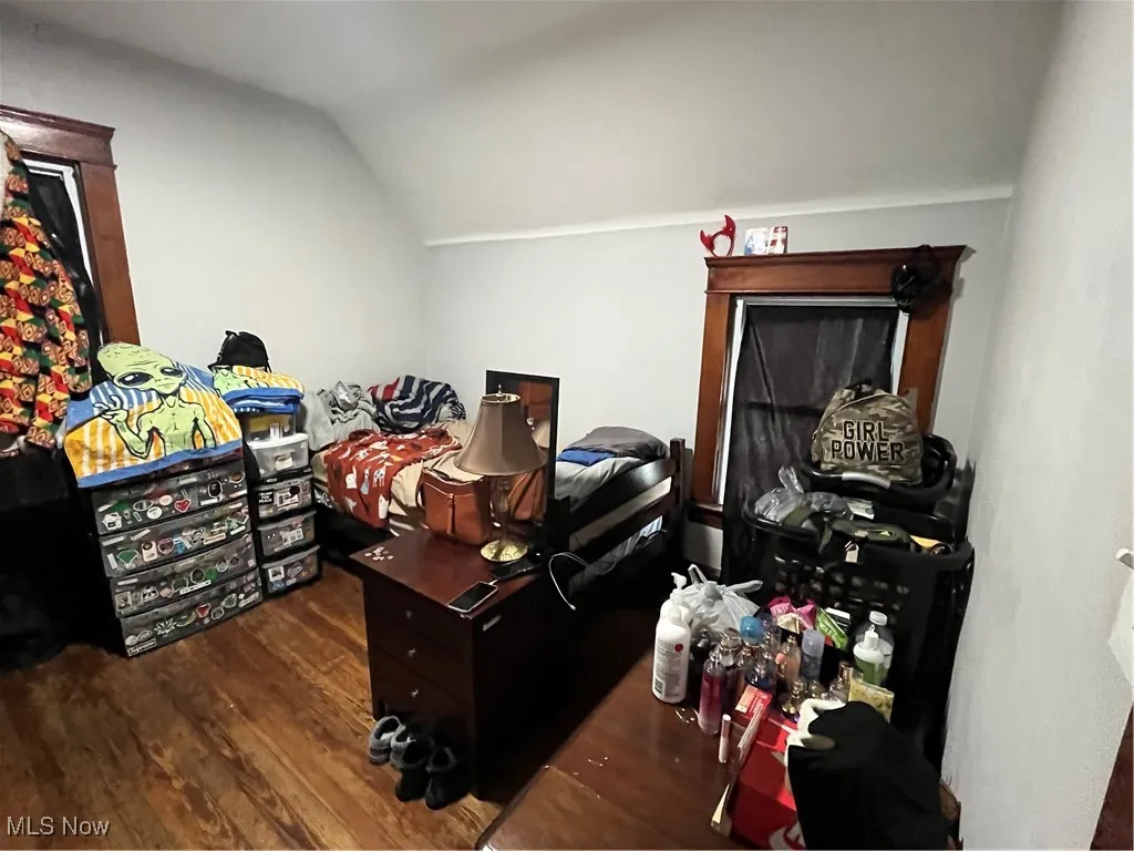 Bedroom featuring lofted ceiling and dark wood-type flooring