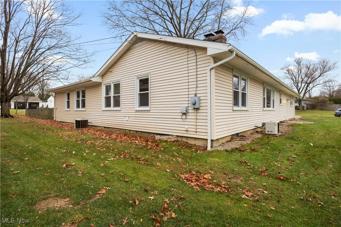 View of property exterior with a chimney and a central AC unit