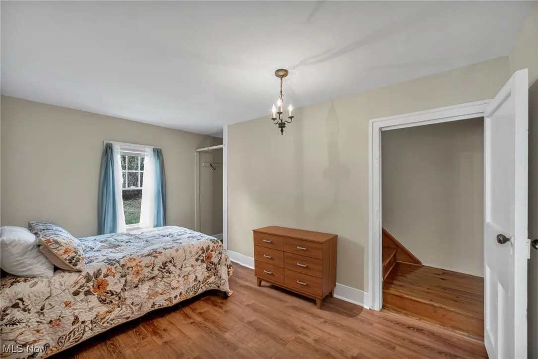 Bedroom with wood finished floors, a closet, and a chandelier