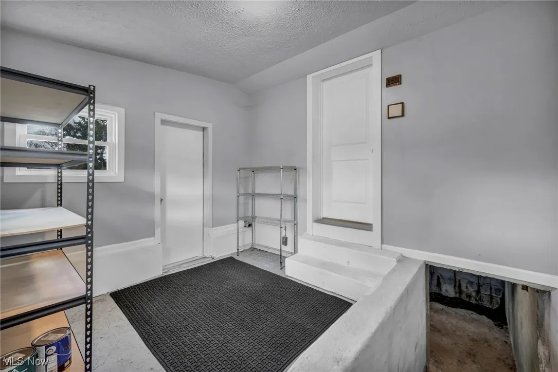 Miscellaneous room featuring a textured ceiling and concrete floors