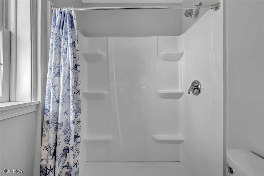 Full bathroom featuring a shower stall