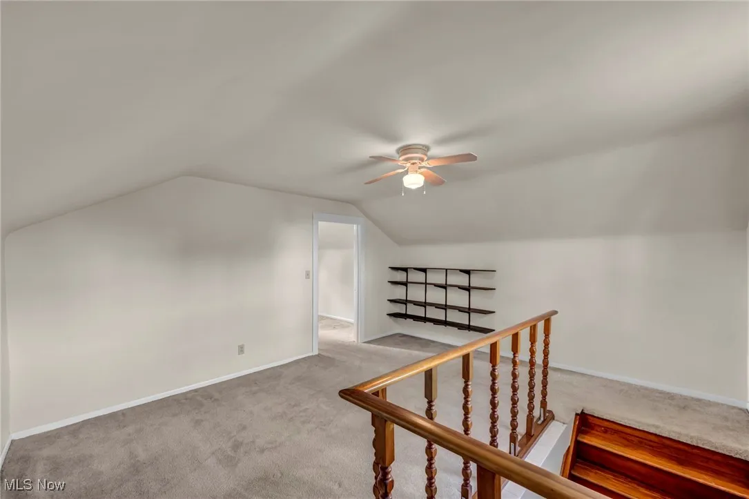 Bonus room featuring carpet flooring, vaulted ceiling, and a ceiling fan