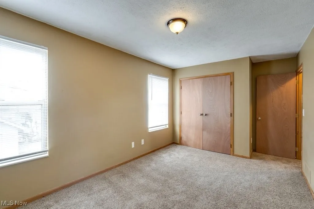 Unfurnished bedroom with a textured ceiling, a closet, and carpet