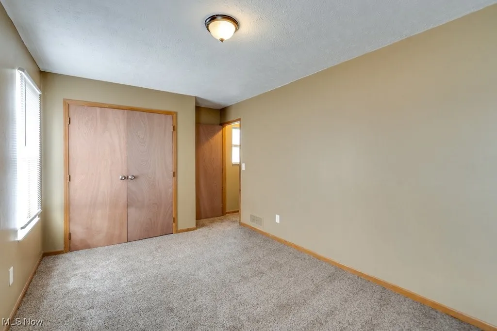 Unfurnished bedroom featuring a closet, carpet floors, and a textured ceiling
